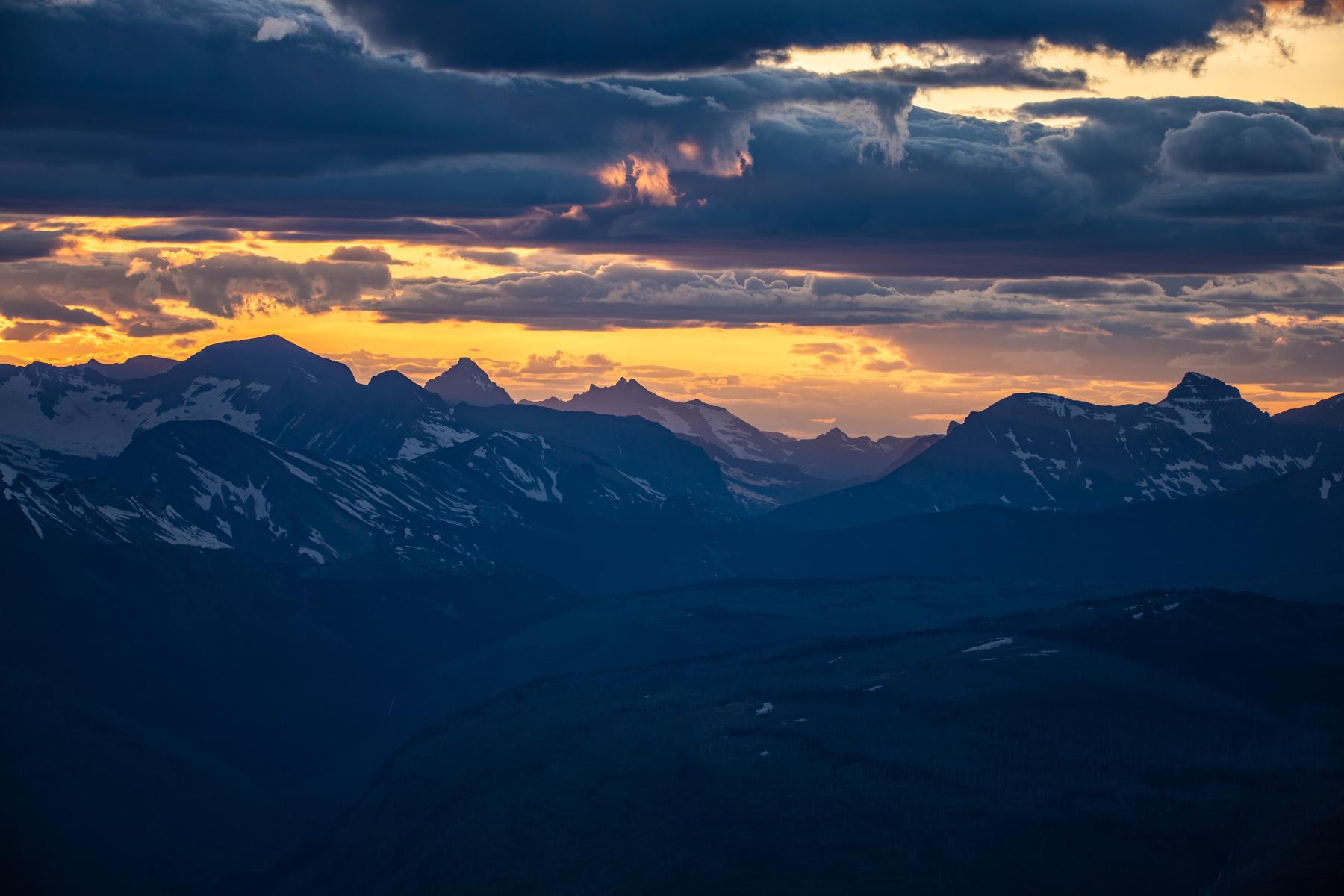 Blue mountains and a golden sunset with clouds