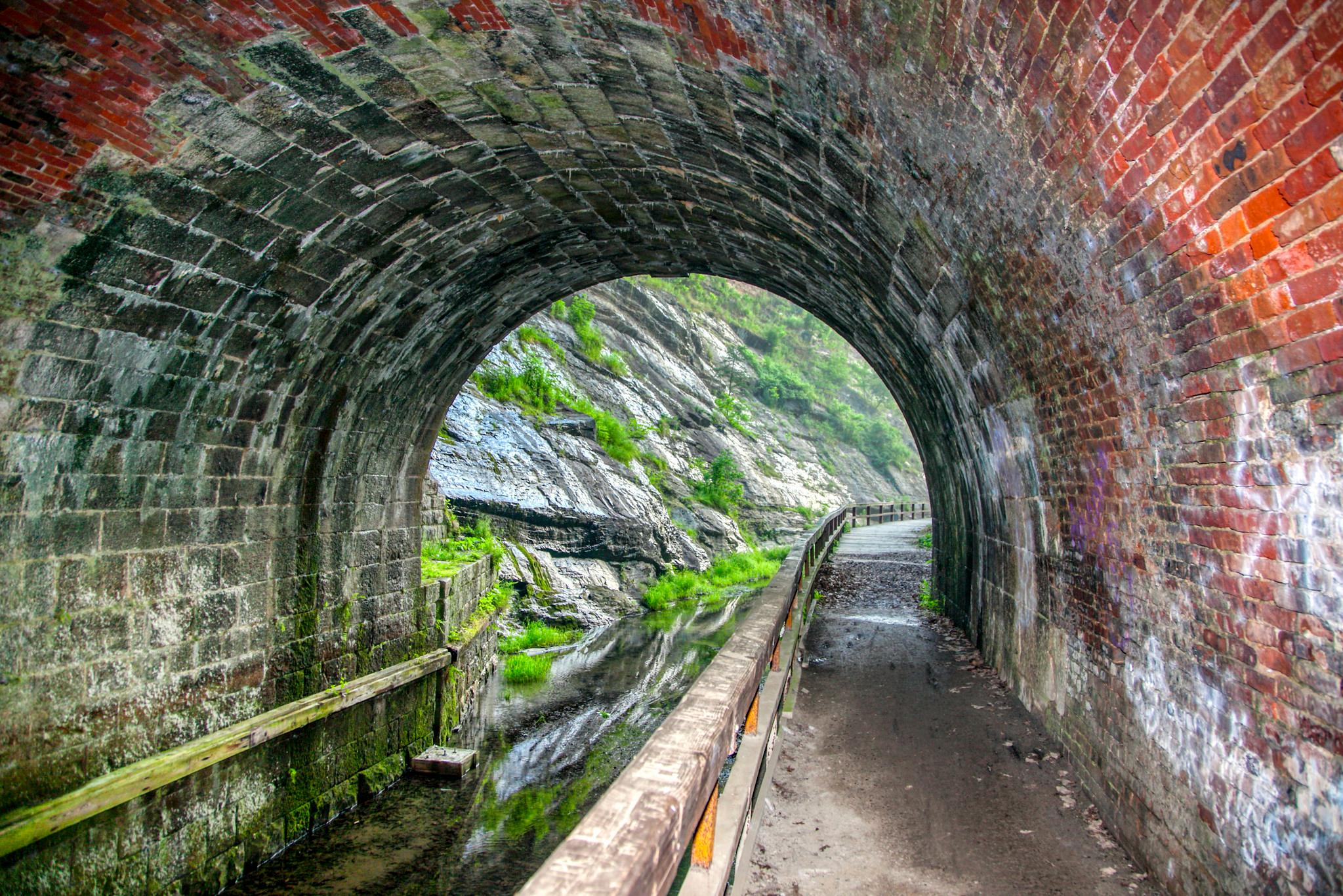 inside view of a brick tunnel next to a canal