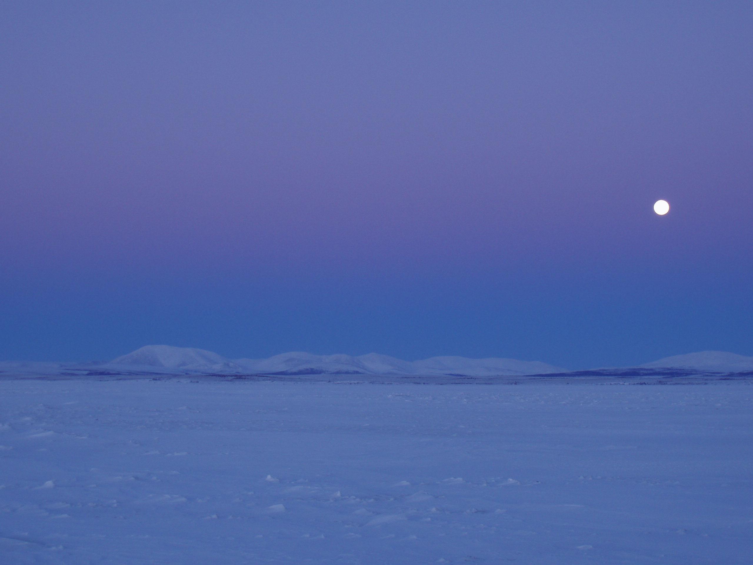 moon over snow covered hills